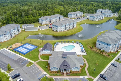 A bird's eye view of a resort with a swimming pool and a lake.