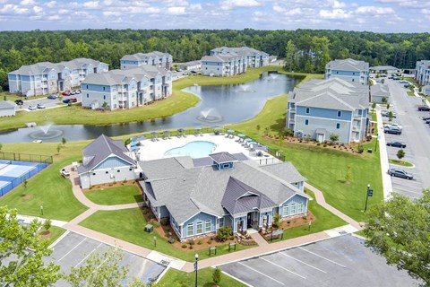A large building with a pool in front of it.