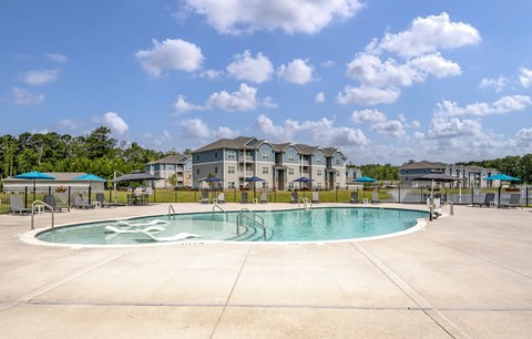A swimming pool in a residential area with houses in the background.