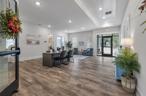 A room with a desk and chairs in it.