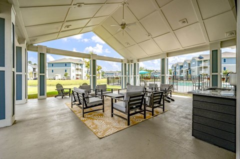 A patio with a table and chairs is covered by a roof.