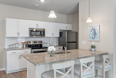 A kitchen with a granite countertop and white cabinets.