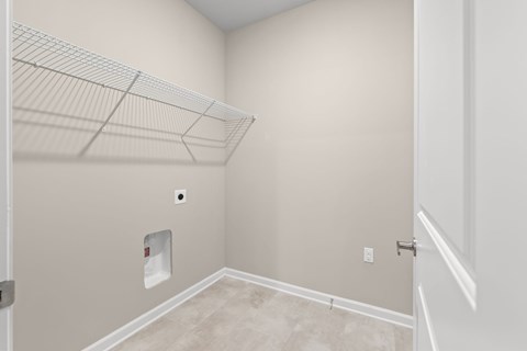 A room with a white door and a white shelf on the wall.