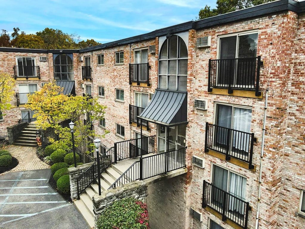 A brick building with balconies and a black metal railing.