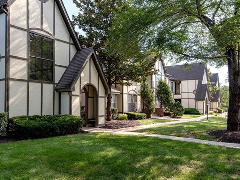 A white house with a black roof and a brown door.