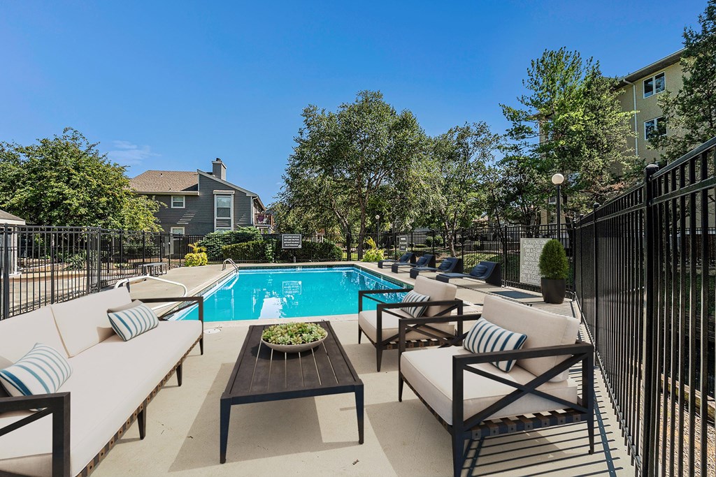 A poolside area with lounge chairs and a table.