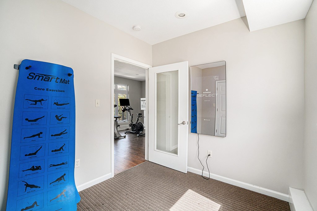 A room with a blue poster on the wall and a white door.