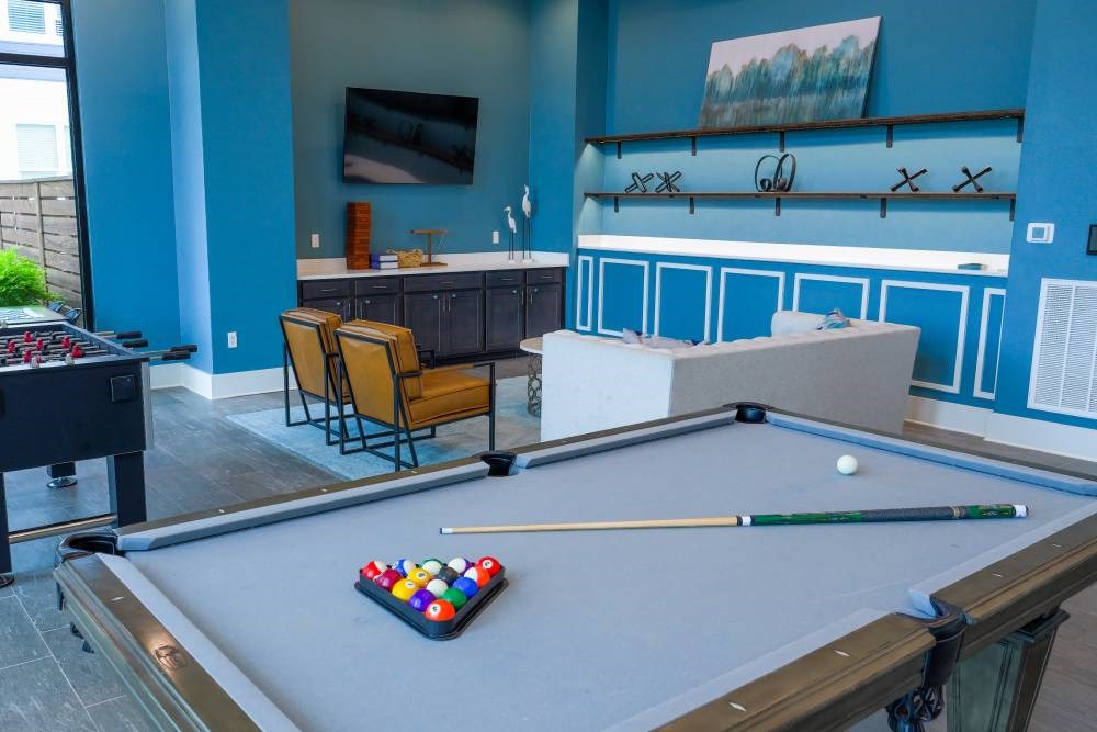 A pool table with a set of balls and a cue stick on it.