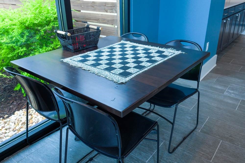 A chess board is on a table with four chairs.