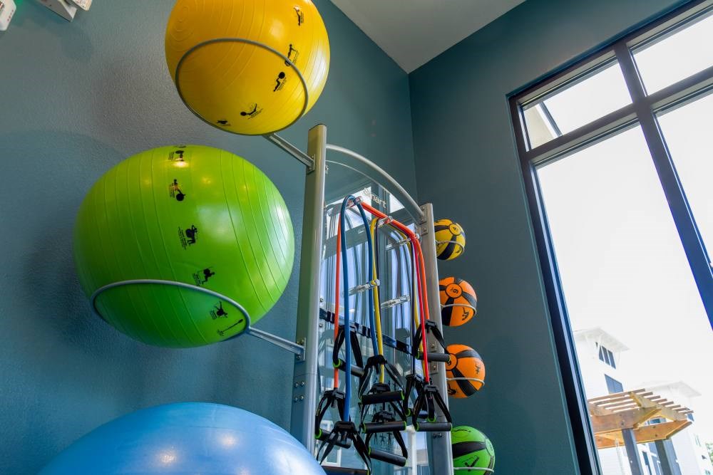 A gym with a blue wall and a yellow ball hanging from the ceiling.