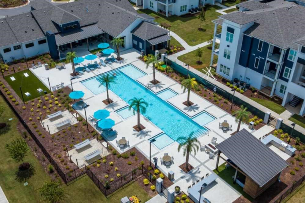 A large swimming pool surrounded by palm trees and lounge chairs.