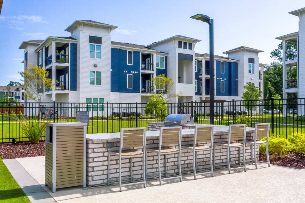 A row of chairs are lined up on a concrete walkway in front of a building.