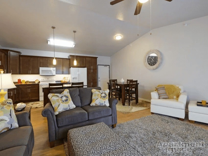 A living room with a grey couch and a white chair.