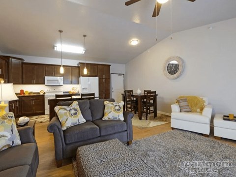 A living room with a grey couch and a white chair.