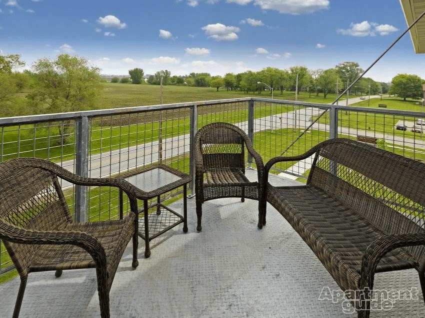 A patio with a table, two chairs and a bench.