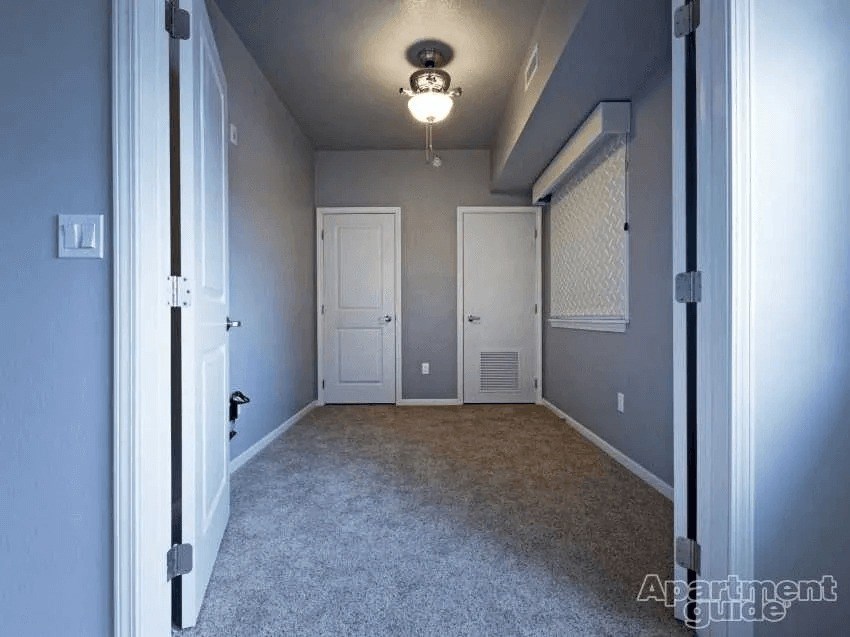 Apartment guide logo on a carpeted hallway with doors on either side.