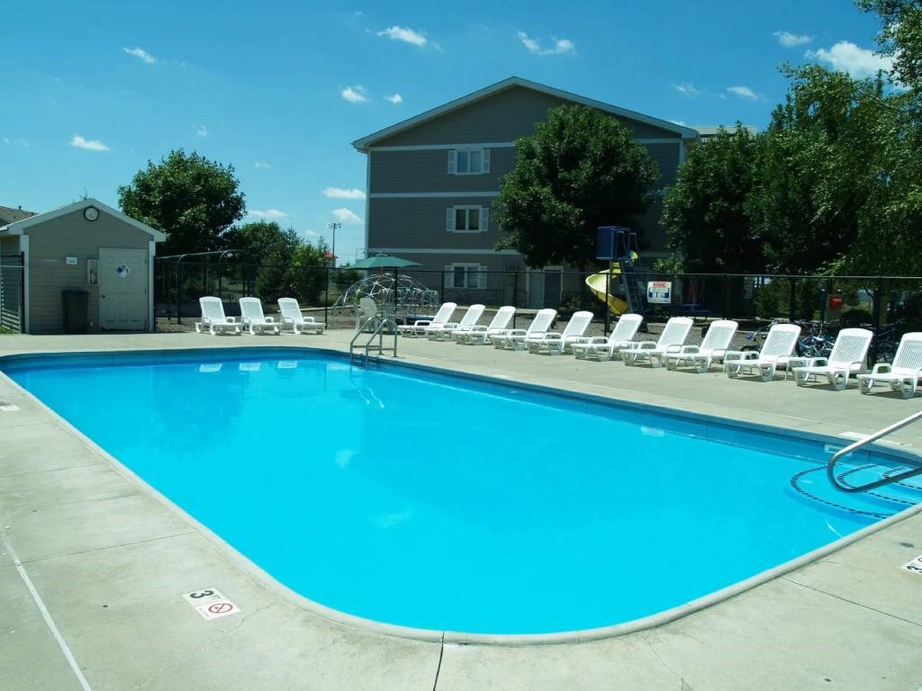 A swimming pool with chairs around it.