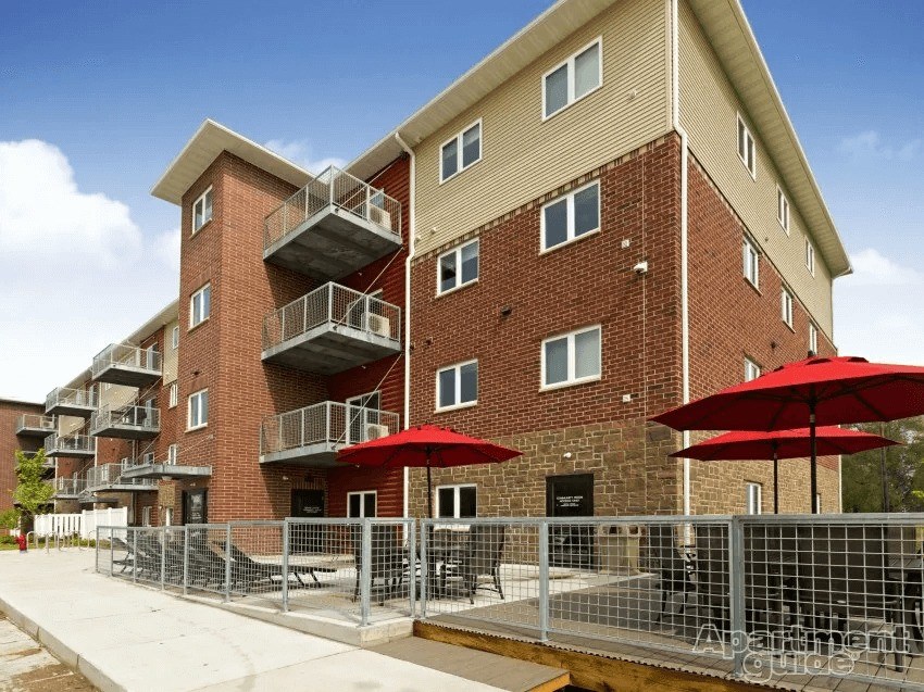 Apartment building with red umbrellas in front.