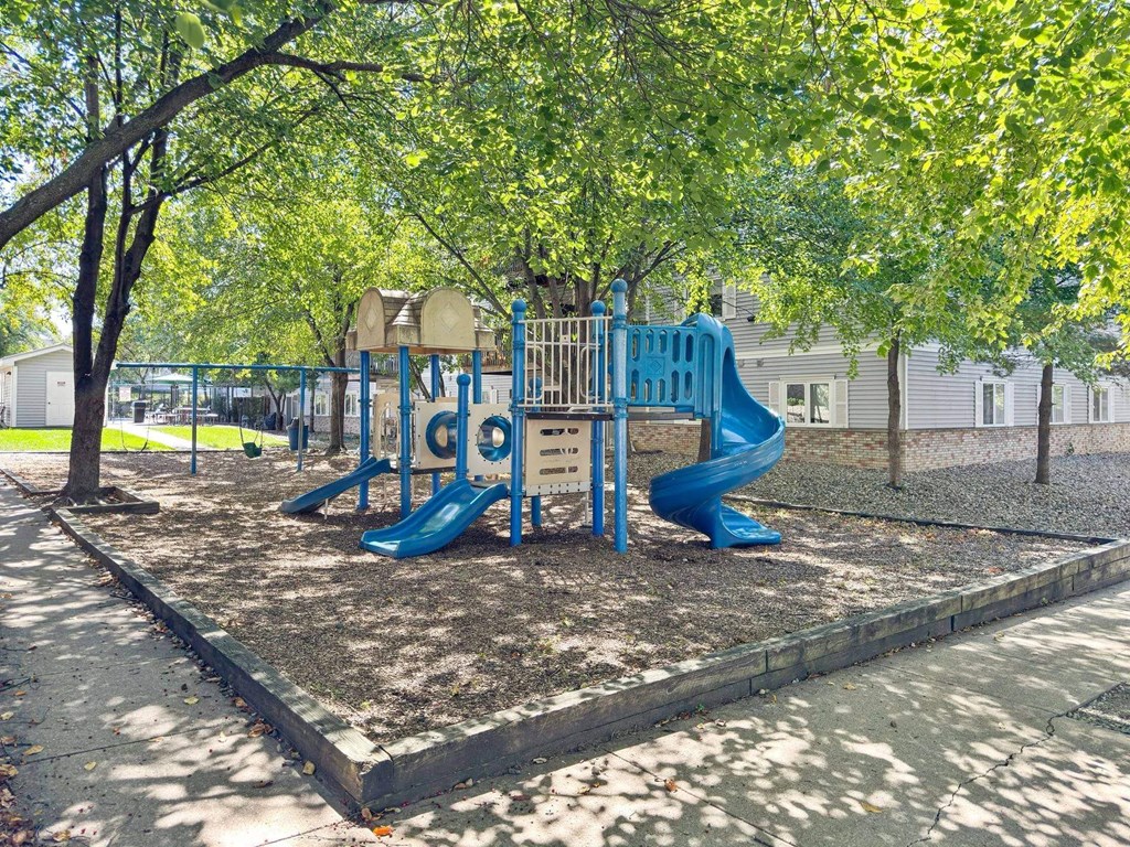 A playground with a blue slide and a yellow structure.
