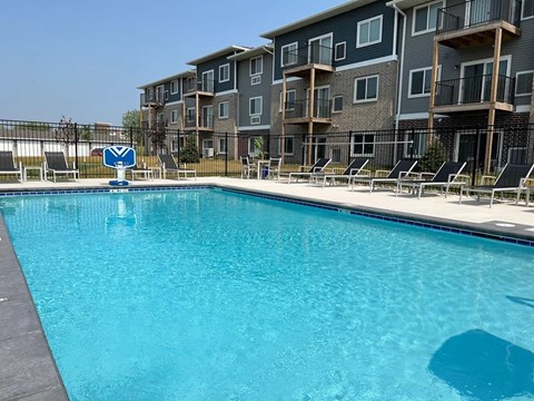 A swimming pool in front of apartment buildings.
