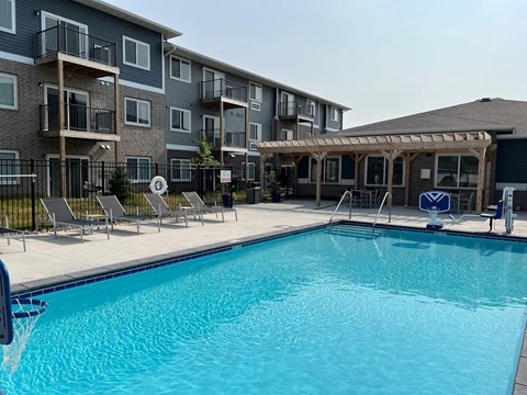 A swimming pool in front of apartment buildings.