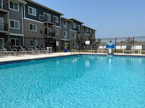 A swimming pool in front of apartment buildings.