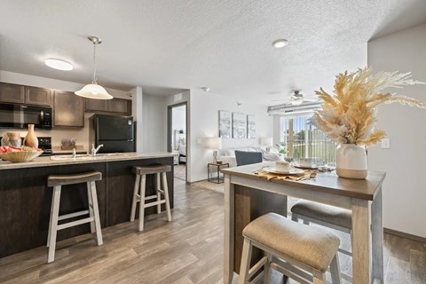 A kitchen with a bar area and a dining table with chairs.