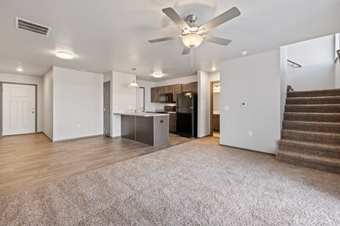 A spacious living room with a staircase on the right side.