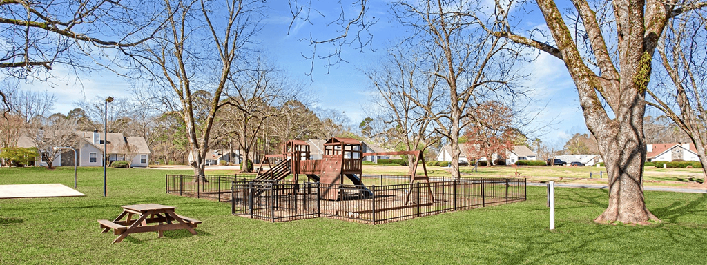 A playground with a slide and a picnic table.