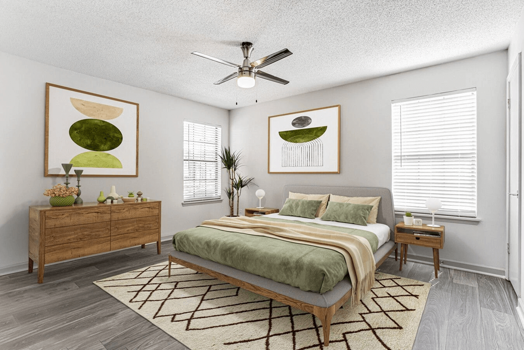 A bedroom with a bed, nightstand, and a painting on the wall.