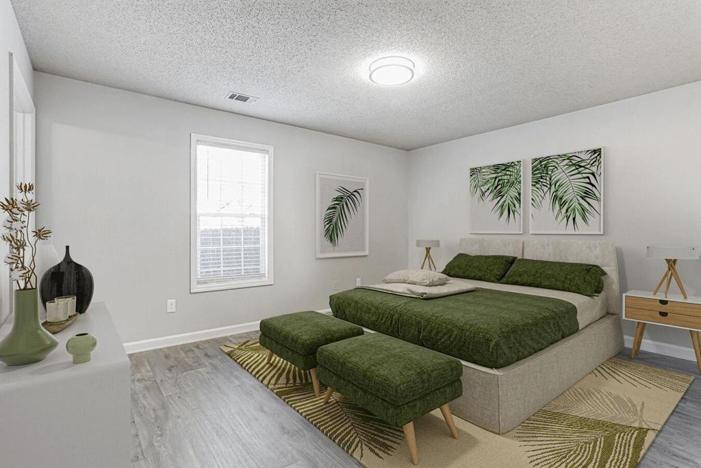 A bedroom with a large bed and a green rug.