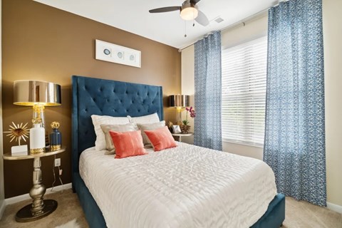 A bedroom with a white bed and a blue headboard.
