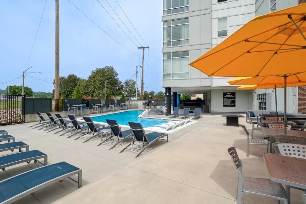 A pool area with sun loungers and umbrellas.at Century Bridges, Roanoke Virginia