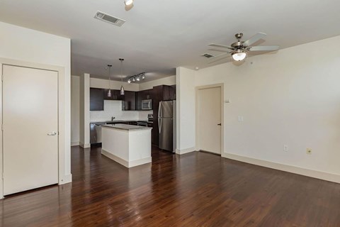 A kitchen with a refrigerator, sink, and stove is visible from the living room.at Century Cedar Hill, Texas, 75104