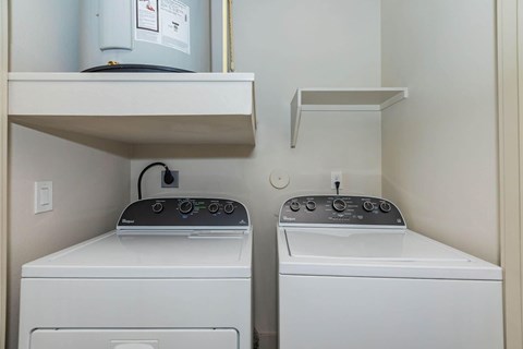 Two washing machines in a small laundry room.at Century Cedar Hill, Cedar Hill Texas
