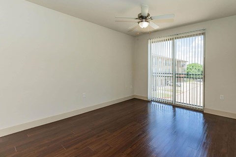 A room with a ceiling fan and sliding glass doors.at Century Cedar Hill, Cedar Hill, TX 75104