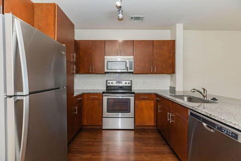 A kitchen with a refrigerator, oven, and microwave.at Century Cedar Hill, Cedar Hill