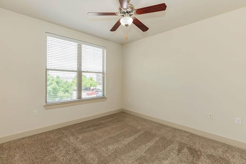 A room with a ceiling fan and a window with blinds.at Century Cedar Hill, Cedar Hill, TX 75104
