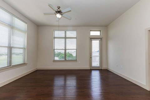 A room with a ceiling fan and wooden flooring.at Century Cedar Hill, Cedar Hill
