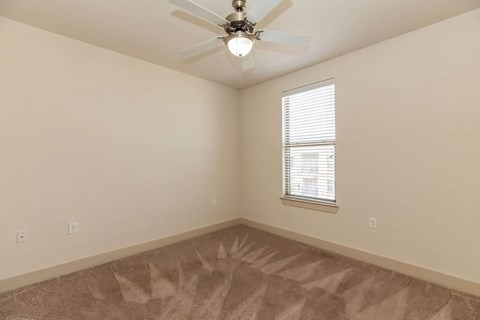 A room with a ceiling fan and a window with blinds.at Century Cedar Hill, Cedar Hill