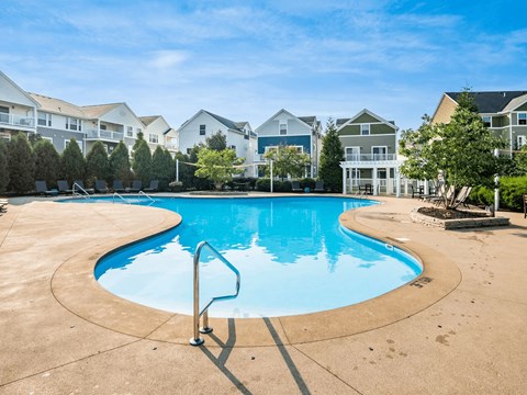 A swimming pool in a residential area with houses in the background.