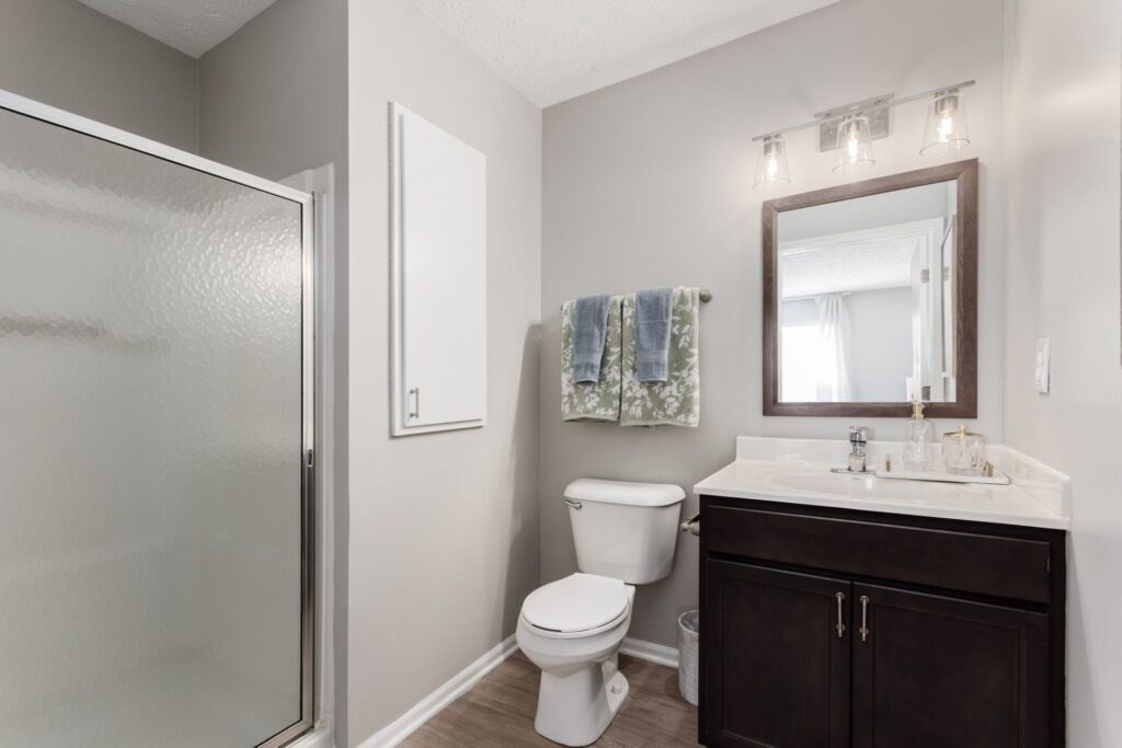 A bathroom with a toilet, sink, and shower.