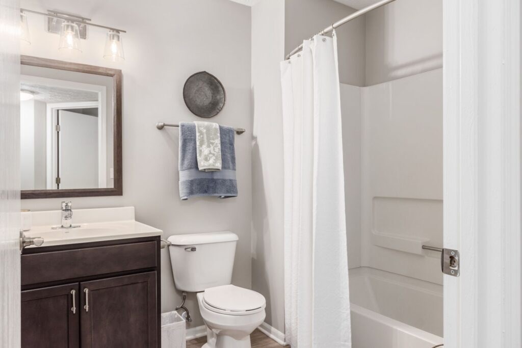 A white toilet sits next to a sink in a bathroom.