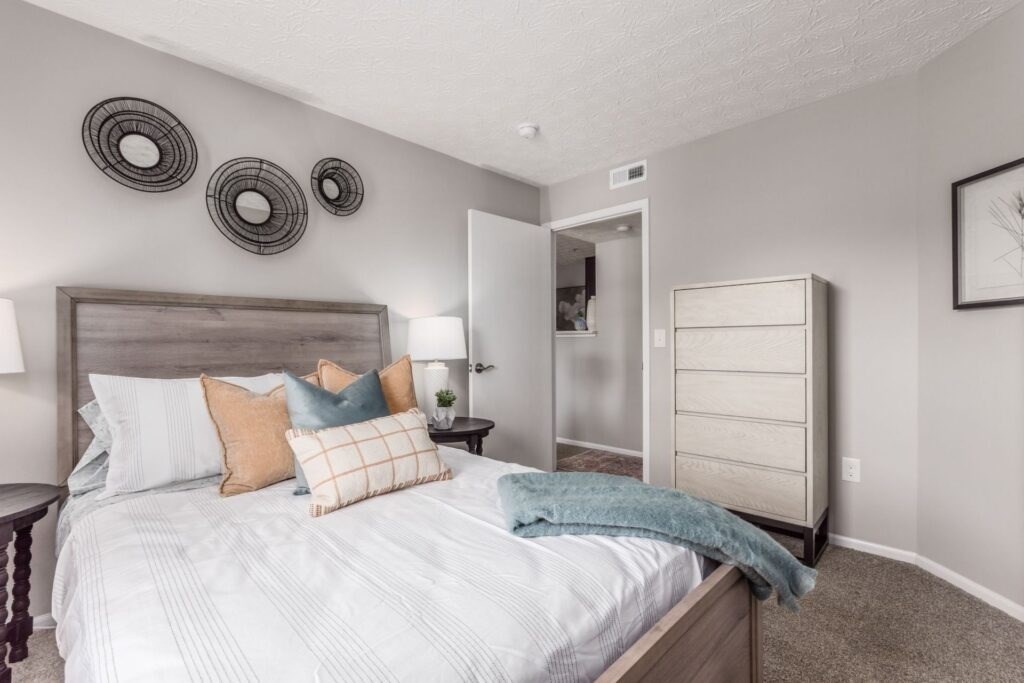 A bedroom with a large bed and a nightstand with a lamp.