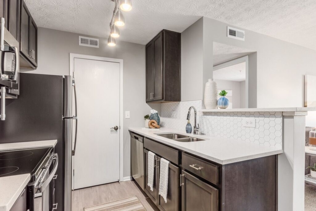 A kitchen with dark brown cabinets and a white counter.