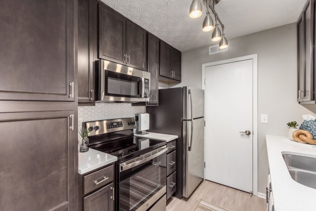 A kitchen with dark brown cabinets and stainless steel appliances.