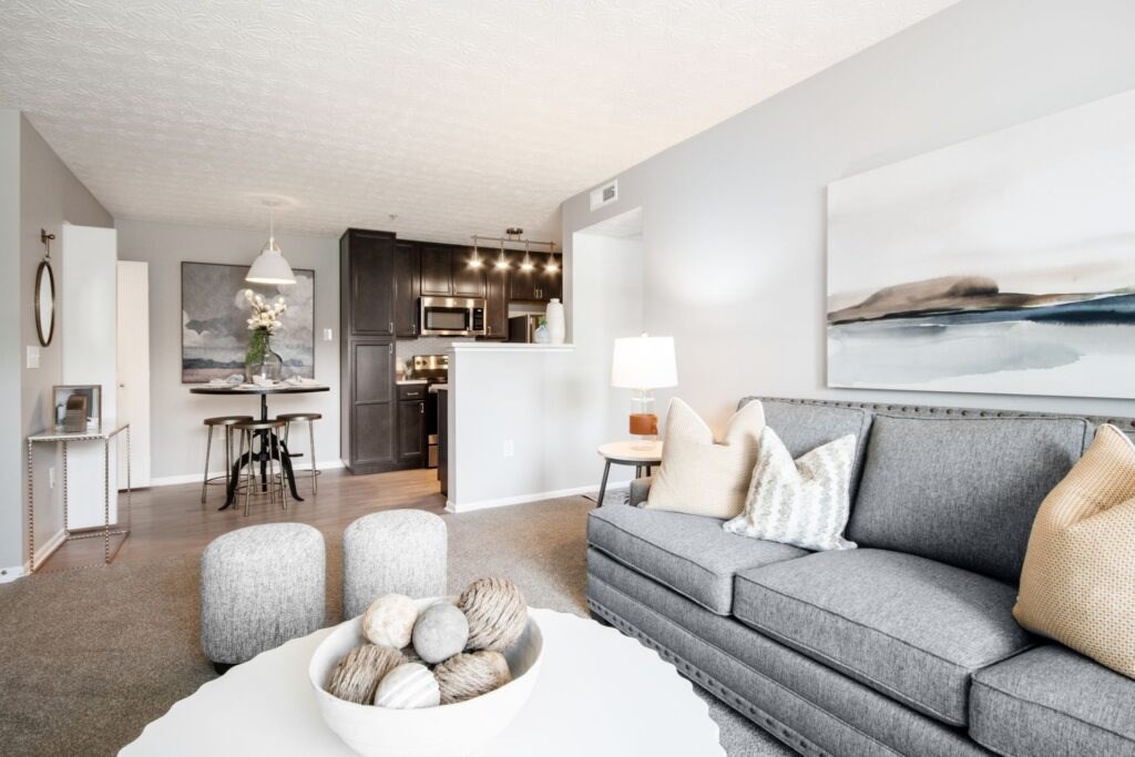 A modern living room with a grey couch and a white coffee table.