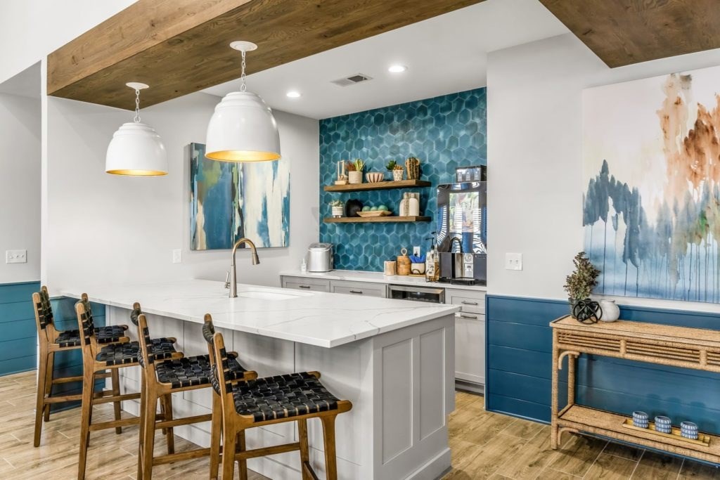 A kitchen with a white counter and wooden chairs.