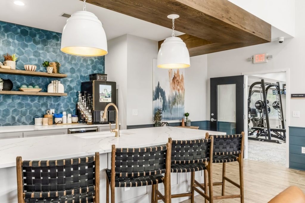A kitchen with a white countertop and black chairs.