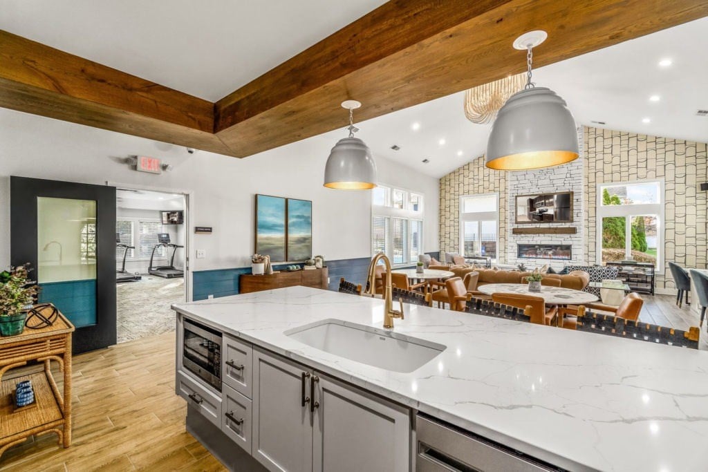 A modern kitchen with a large island and a wooden ceiling.